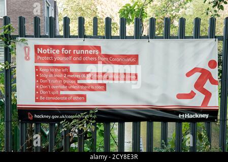 Avviso per i runner segno o banner che consiglia ai runner di proteggere il loro sé e altri da Coronavirus Covid19, Woodberry Wetlands Stoke Newington London Foto Stock