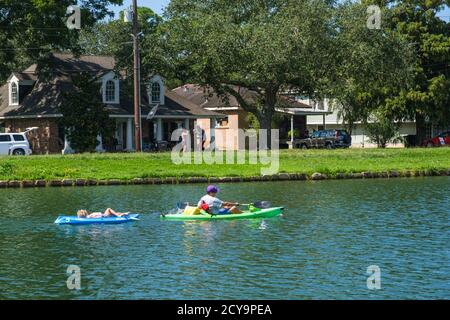 New Orleans, Louisiana/USA - 9/27/2020: Uomo che va in kayak e traina bambino su Bayou San Giovanni con uomo e donna che si inpugnano in background Foto Stock