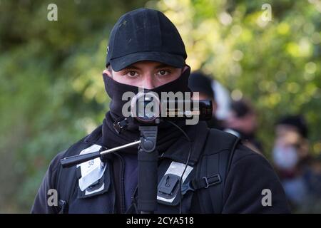 Aylesbury vale, Regno Unito. 1 ottobre 2020. Un membro del National Eviction Team utilizza una telecamera di sorveglianza durante lo sfratto di attivisti anti-HS2 da un campo di protezione della fauna selvatica in un antico bosco a JonesÕ Hill Wood. Circa 40 attivisti ambientali e residenti locali, alcuni dei quali vivono in case di alberi di fortuna a 60 metri sopra il suolo, Erano presenti durante gli sfratti a JonesÕ Hill Wood che aveva servito come uno dei numerosi campi di protesta allestiti lungo il percorso del £106bn HS2 collegamento ferroviario ad alta velocità per resistere al controverso progetto infrastrutturale.Credit: Mark Kerrison/Alamy L. Foto Stock