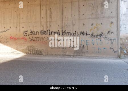 Scritti su un muro vicino alla strada. Le parole sono in lingua turca. Foto Stock