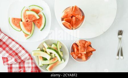 Macedonia di frutta. Le fette di cocomero fresco si avvicinano in una ciotola sul tavolo da cucina direttamente dall'alto Foto Stock