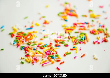 Fuoco selettivo zucchero colorato cospargere i punti per la decorazione di torta e gelato sul tavolo. Foto Stock