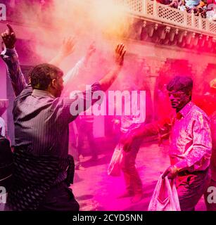 Nandgeon, India, Holi festival, Feb 25, 2018 - Uomini buttare la vernice rossa polvere mentre balli durante il Festival del colore in India Foto Stock