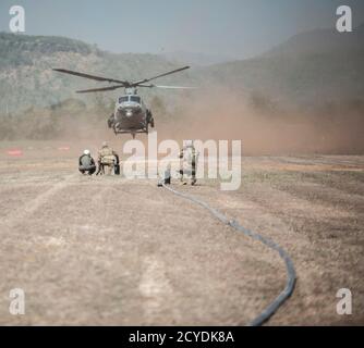 U.S. Air Force 18th Logistics Readiness Squadron Forward area Refuelling Point (FARP) tecnici e 1st Special Operations Squadron loadmaster si preparano ad eseguire operazioni FARP con un US Marine Corps 1st Marine Aviation Wing UH-1 Huey 14 febbraio 2018, a Chandy Range, Thailandia. La capacità FARP del 353a Special Operations Group fornisce un'opzione di rifornimento con copertura in situazioni in cui non sono possibili le tradizionali capacità di rifornimento. (STATI UNITI Air Force foto di Capt. Jessica Tait) Foto Stock