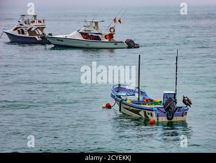 Puerto Lopez, Ecuador - 12 settembre 2018 - una piccola barca di gara arriva fino alla spiaggia da una barca da pesca Foto Stock