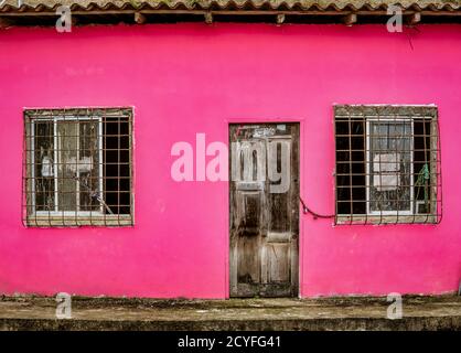 La Entrade, Ecuador - 14 settembre 2018 - porta non verniciata sul muro rosso Foto Stock