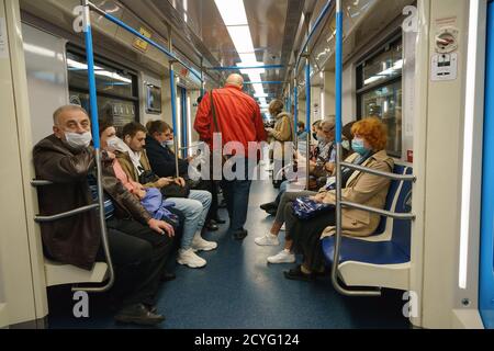 Mosca, Russia - 29 agosto 2020: Fotografia di persone in carrozza di metropolitana. Qualcuno seduto, utilizzando lo smartphone. Indossare / indossare / usare protectiv Foto Stock