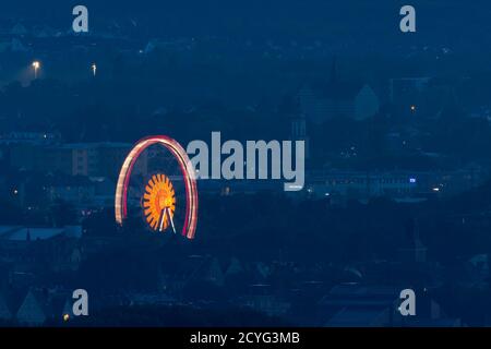 Grande ruota in ferro illuminata che si trova nel centro di Ratisbona Sulla Ernst-Reuter-Platz durante la pandemia di Covid di notte vista dal mountain Keil Foto Stock