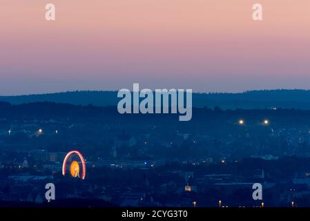 Grande ruota in ferro illuminata che si trova nel centro di Ratisbona Sulla Ernst-Reuter-Platz durante la pandemia di Covid di notte vista dal mountain Keil Foto Stock