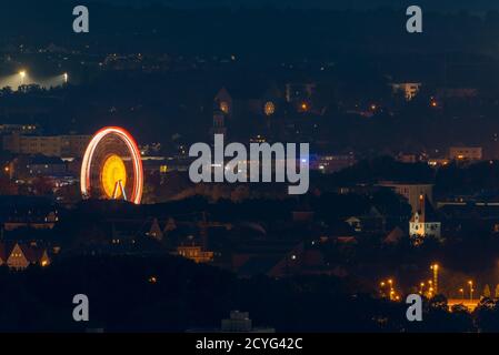 Grande ruota in ferro illuminata che si trova nel centro di Ratisbona Sulla Ernst-Reuter-Platz durante la pandemia di Covid di notte vista dal mountain Keil Foto Stock