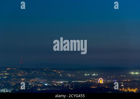 Grande ruota in ferro illuminata che si trova nel centro di Ratisbona Sulla Ernst-Reuter-Platz durante la pandemia di Covid di notte vista dal mountain Keil Foto Stock