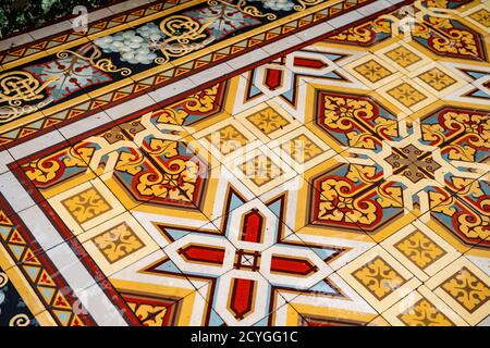 Pavimenti in piastrelle con ornamenti arabescati di colore giallo, bianco e rosso. Foto Stock