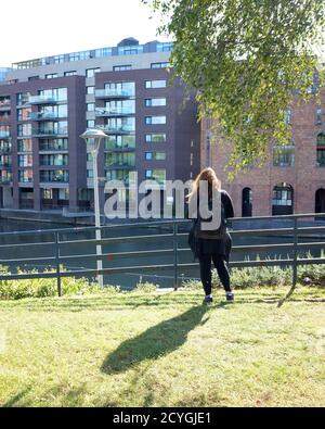 Ottobre 2020 - la donna dai capelli lunghi con il gazing delle ombre ai nuovi Finzels raggiunge lo sviluppo di proprietà nella città di Bristol, Inghilterra, Regno Unito Foto Stock