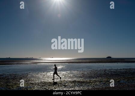 Uno Jogger solone di mattina presto sulla spiaggia del Priory sull'isola di Wight. 22 agosto 2016. Foto: Neil Turner Foto Stock