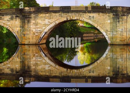 Riflessioni del Ponte Vecchio di Ferrybridge che porta la vecchia Great North Road attraverso il fiume Aire. Foto Stock