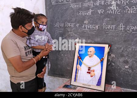 Beawar, Rajasthan, India, 2 ottobre 2020: Un insegnante con sua figlia rende omaggio a Mahatma Gandhi in occasione del suo 151° anniversario di nascita, a Beawar. Credit: Sumit Saraswat/Alamy Live News Foto Stock