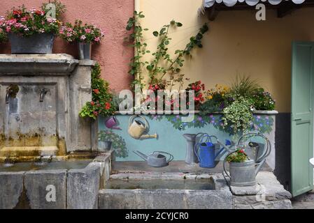 Trompe l'Oeil decorazione o dipinto Fontana Village con Antique o. Lattine d'annaffiatura in metallo antico Colmars-les-Alpes Alpes-de-Haute-Provence Provence Provence France Foto Stock