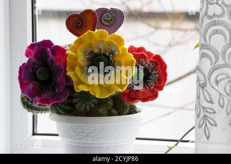 San Valentino, prodotti fatti a mano da feltro, due cuori e tre fiori da feltro su un cactus Foto Stock