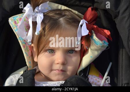 Little Girl durante la festa nazionale del Qatar indossare i colori Di Qatari Bandiera nei capelli Foto Stock