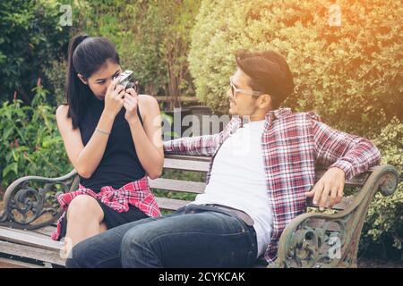 Giovane coppia trascorrere insieme il tempo nel parco in estate giornata di sole. Scattare foto l'una dell'altra. Foto Stock