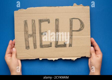 la mano contiene un pezzo di cartone con l'iscrizione di aiuto, il concetto di assistenza reciproca, senza tetto, crisi finanziaria Foto Stock