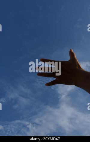 Man mano posizione, cercare di toccare il cielo Foto Stock