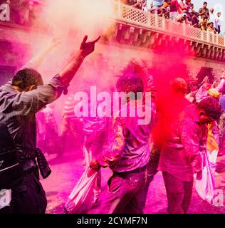 Nandgeon, India, Holi festival, Feb 25, 2018 - Uomini buttare la vernice rossa polvere mentre balli durante il Festival del colore in India Foto Stock