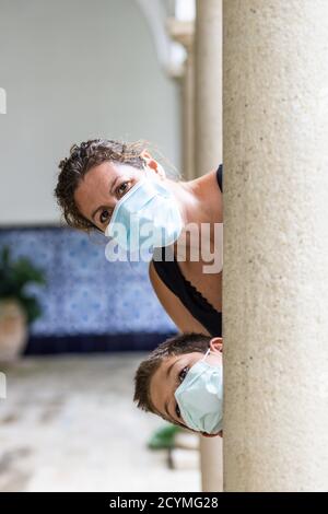 Madre e figlio con un viso maschere che giocano Foto Stock