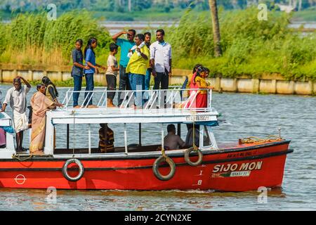 Piccola barca turistica con passeggeri indiani in procinto di visitare una vecchia chiesa su una delle popolari crociere in mare; Alappuzha (Alleppey), Kerala, India Foto Stock