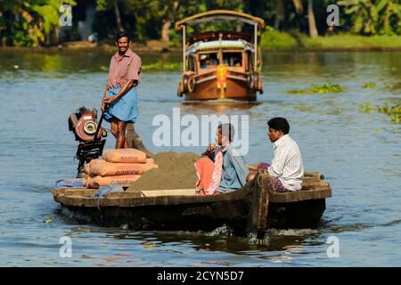 Operai su piccola chiatta carico di cemento per la costruzione in un distretto locale di backwaters di questa regione di crociera; Alappuzha (Alleppey), Kerala, India Foto Stock