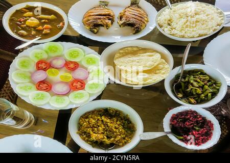 Pasto tipico indiano sull'acqua posteriore casa gallegante: Riso, fagioli, cavolo, curry, papad, pesce fritto; Alappuzha (Alleppey), Kerala, India Foto Stock