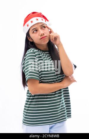 ritratto di giovane donna asiatica che indossa un cappello di santa e. indossare abiti casual che sollevano un dito vicino alla testa guarda pensare con un backg bianco isolato Foto Stock