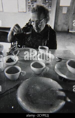 Bella fotografia in bianco e nero degli anni '70 dei bambini che consumeranno il pranzo presso la caffetteria. Foto Stock