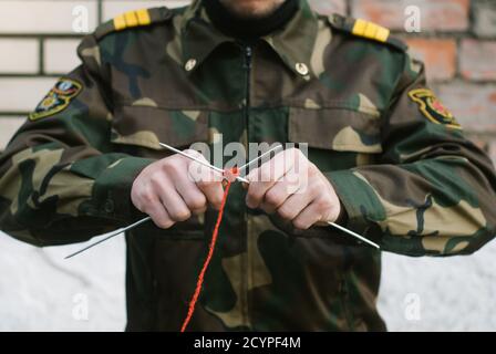 un soldato in maglia uniforme con aghi e filo rosso, Foto Stock