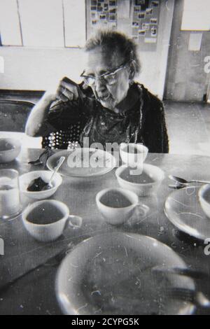 Bella fotografia in bianco e nero degli anni '70 dei bambini che consumeranno il pranzo presso la caffetteria. Foto Stock