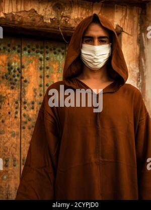 Uomo marocchino berbero con maschera protettiva e Djellaba. Foto Stock