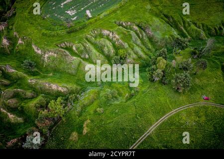 Verdi colline e burroni visti dall'alto, naturale estate sfondo stagionale dal drone Foto Stock