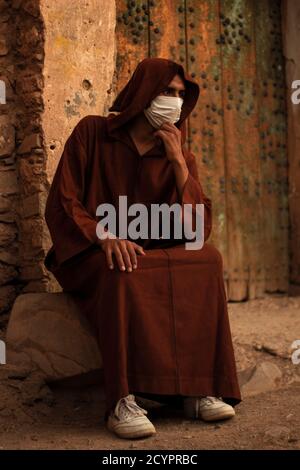 Uomo marocchino berbero con maschera protettiva e Djellaba. Foto Stock