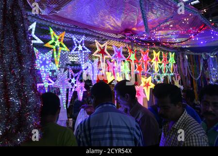 Colorate stelle di Natale illuminate in un mercatino di Natale in Kerala Goa India. Indiane Natale concetto Lightning lanterna di carta o stella appesa Foto Stock