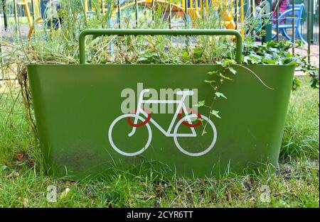 primo piano del parco per biciclette verde con bianco e. logo rosso della bicicletta all'esterno nel parco pubblico in estate Foto Stock