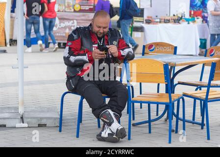 DNIPRO, UCRAINA - 11 MAGGIO 2019: Ritratto di biker maturo seduto in un caffè all'aperto sulla città annuale biker club MC Angels riunione dedicata all'ope Foto Stock