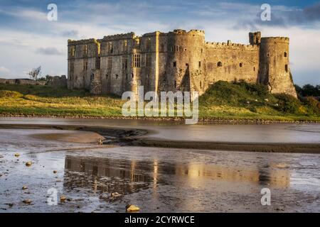 Carew Castle si riflette nel fiume Carew, Pembrokeshire Coast National Park, Pembrokeshire, Galles Foto Stock