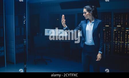 Nel moderno Data Center Research Laboratory Beautiful Confident Woman does Virtual Reality Activating Touch Gesture. Simulazione di realtà aumentata. Foto Stock