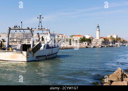 Barca da pesca sulla sua via di ritorno al porto di Le Grau-du-Roi nel pomeriggio (Francia sud-orientale) Foto Stock