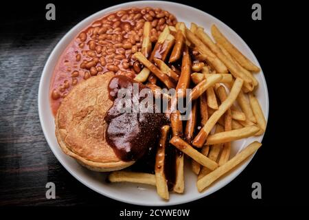 Torta di bistecca e rene, patatine, fagioli e sugo di carne Foto Stock