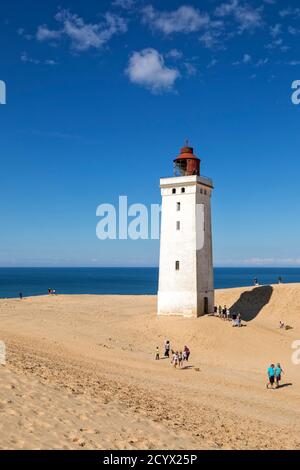 Faro sulla duna a Rubjerg Knude, Danimarca, in una soleggiata giornata estiva. Alcuni visitatori passeggiano, altri in fila per salire sulla storica Foto Stock