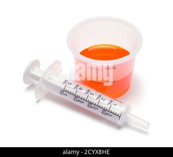 Medicina liquida in tazza con siringa orale. Foto Stock