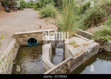 Antica acequia o séquia corso d'acqua gestito dalla comunità utilizzato per l'irrigazione su un sentiero. Benahavis, Andalusia, Spagna. Foto Stock