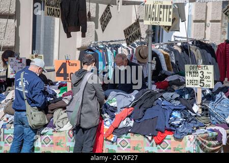 ROMA, ITALIA - OTTOBRE 01 2020: I pedoni si accavallano per i vestiti in vendita in uno stand di mercato a Roma, Italia. Foto Stock