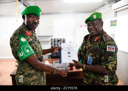 Il vice comandante della forza uscente AMISOM, responsabile delle operazioni e dei piani del generale Charles Tai Gituai (destra), consegna un documento al vice comandante della forza entrante, responsabile delle operazioni e dei piani, il generale James Nakibus Lakara (sinistra), durante una cerimonia di consegna tenutasi a Mogadiscio il martedì, 20 febbraio 2019. Foto Stock